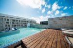 Common area rooftop pool with lounge chairs